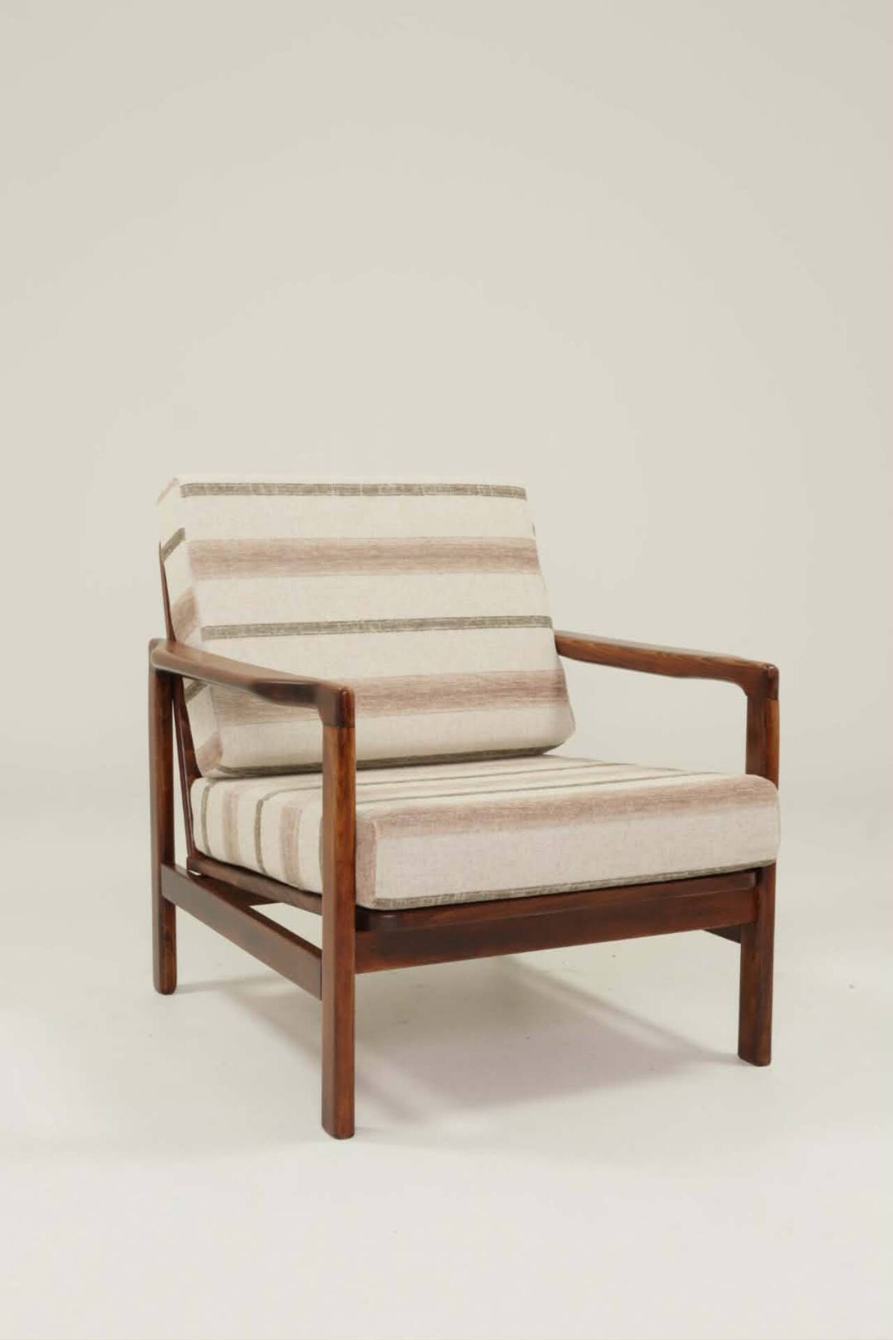 Fauteuil vintage avec des coussins en tissu naturel rayé.