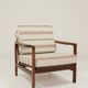 Fauteuil vintage avec des coussins en tissu naturel rayé.