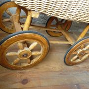 Old wooden cradle and wicker on wheels