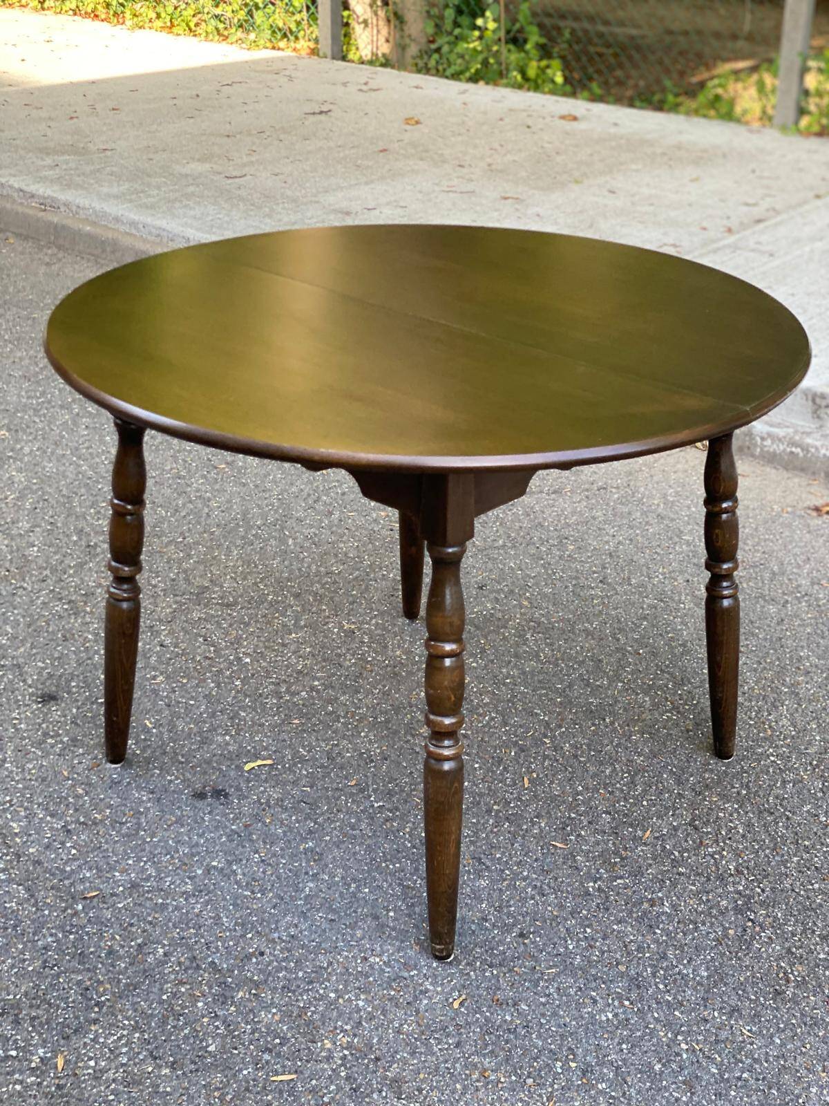 Extendable round table in solid wood with a dark oak satin finish.