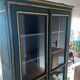 Glass-fronted cabinet in weathered green wood