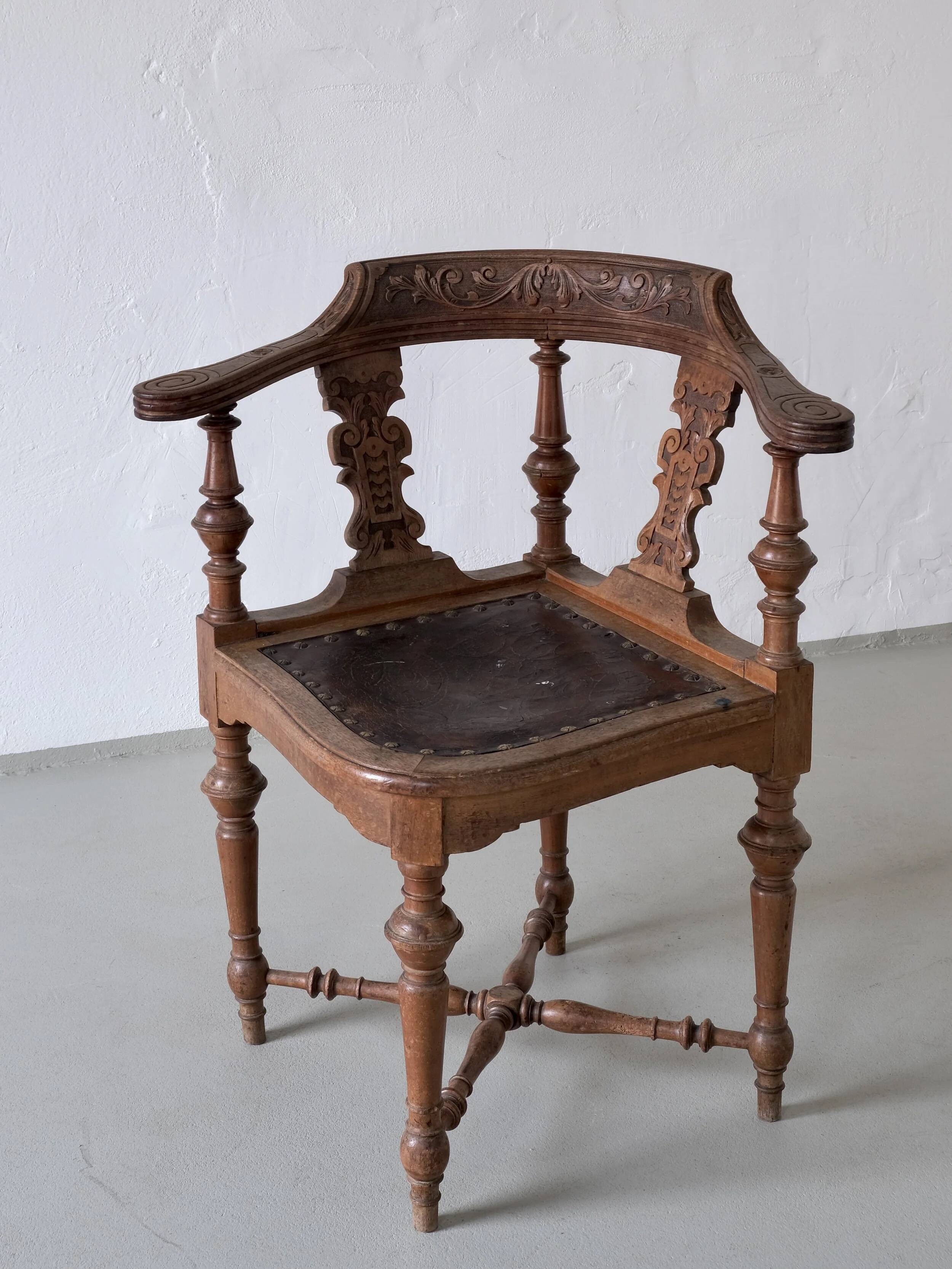 Fauteuil d'angle ancien sculpté avec assise en cuir