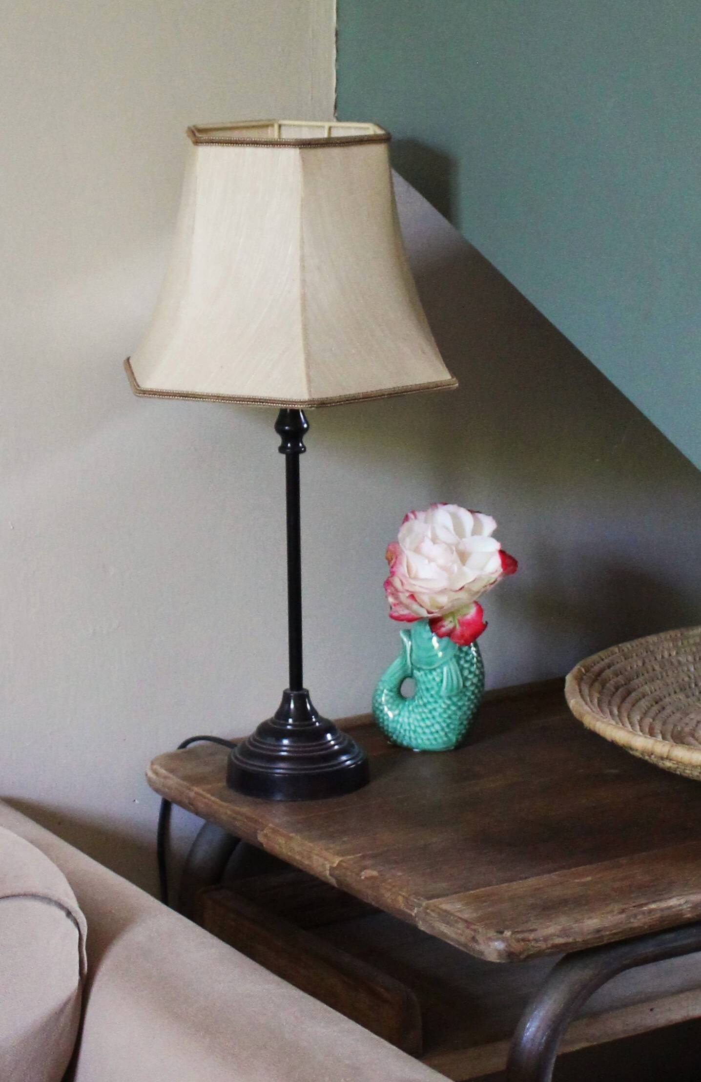 Table lamp with a patinated base and vintage woven shade.