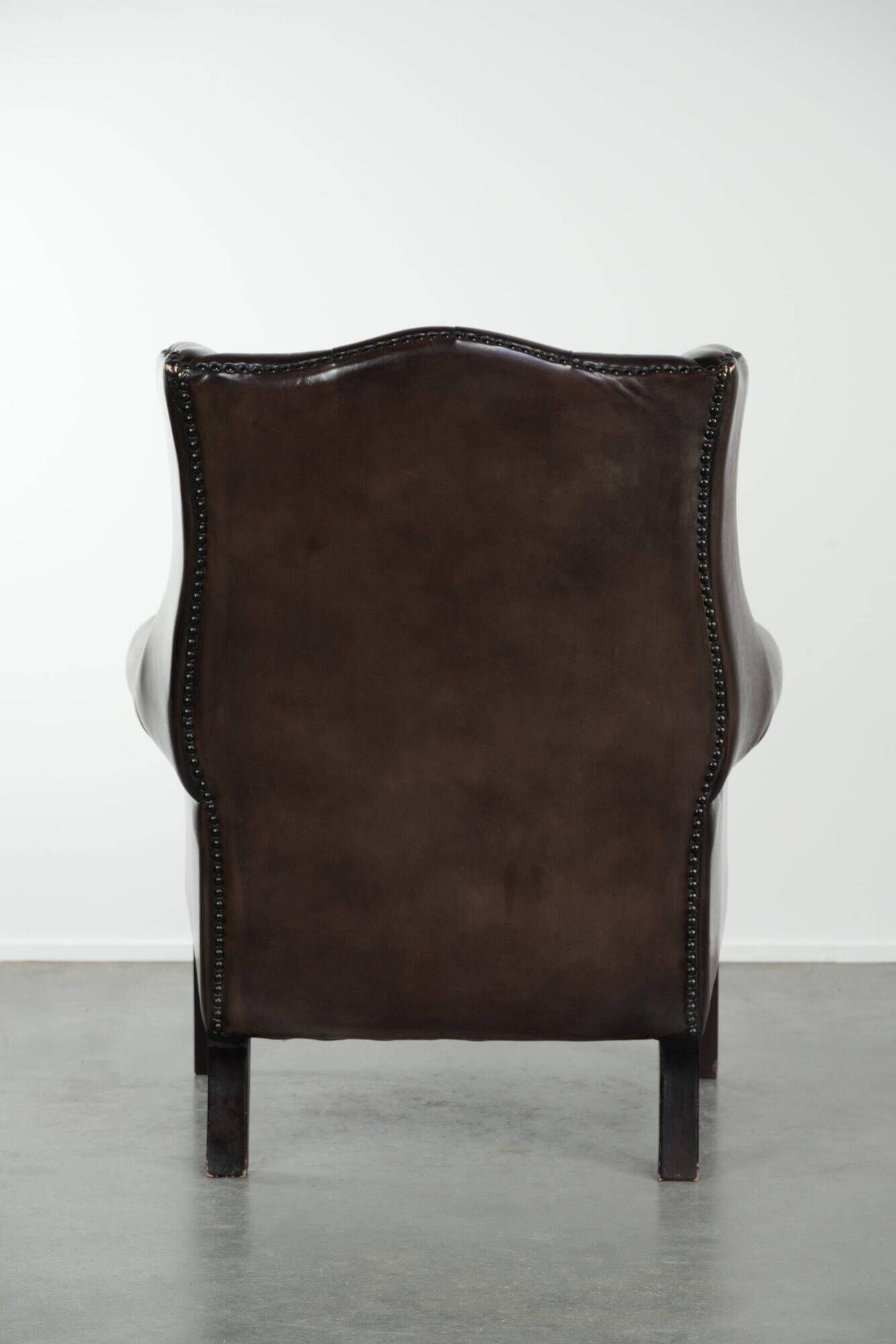 Dark brown cowhide Chesterfield wingback armchair in classic English style