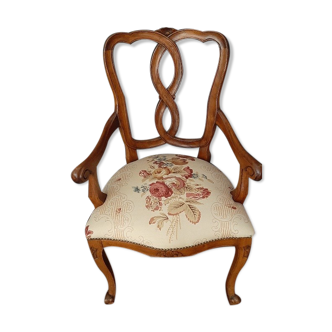 Upholsterer armchair covered with a publisher fabric with a central floral pattern