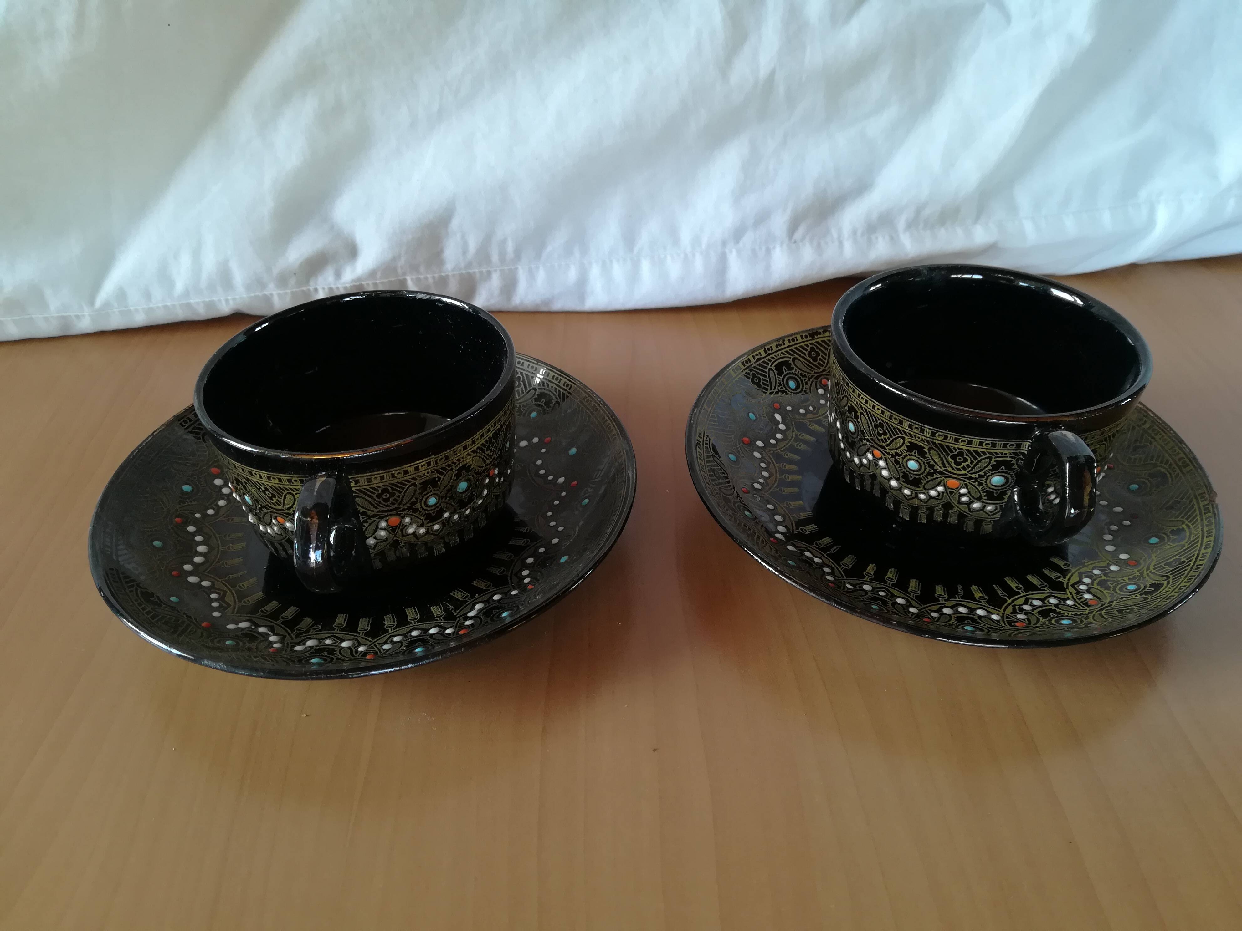 Black cups and saucers with relief decoration