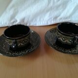 Black cups and saucers with relief decoration