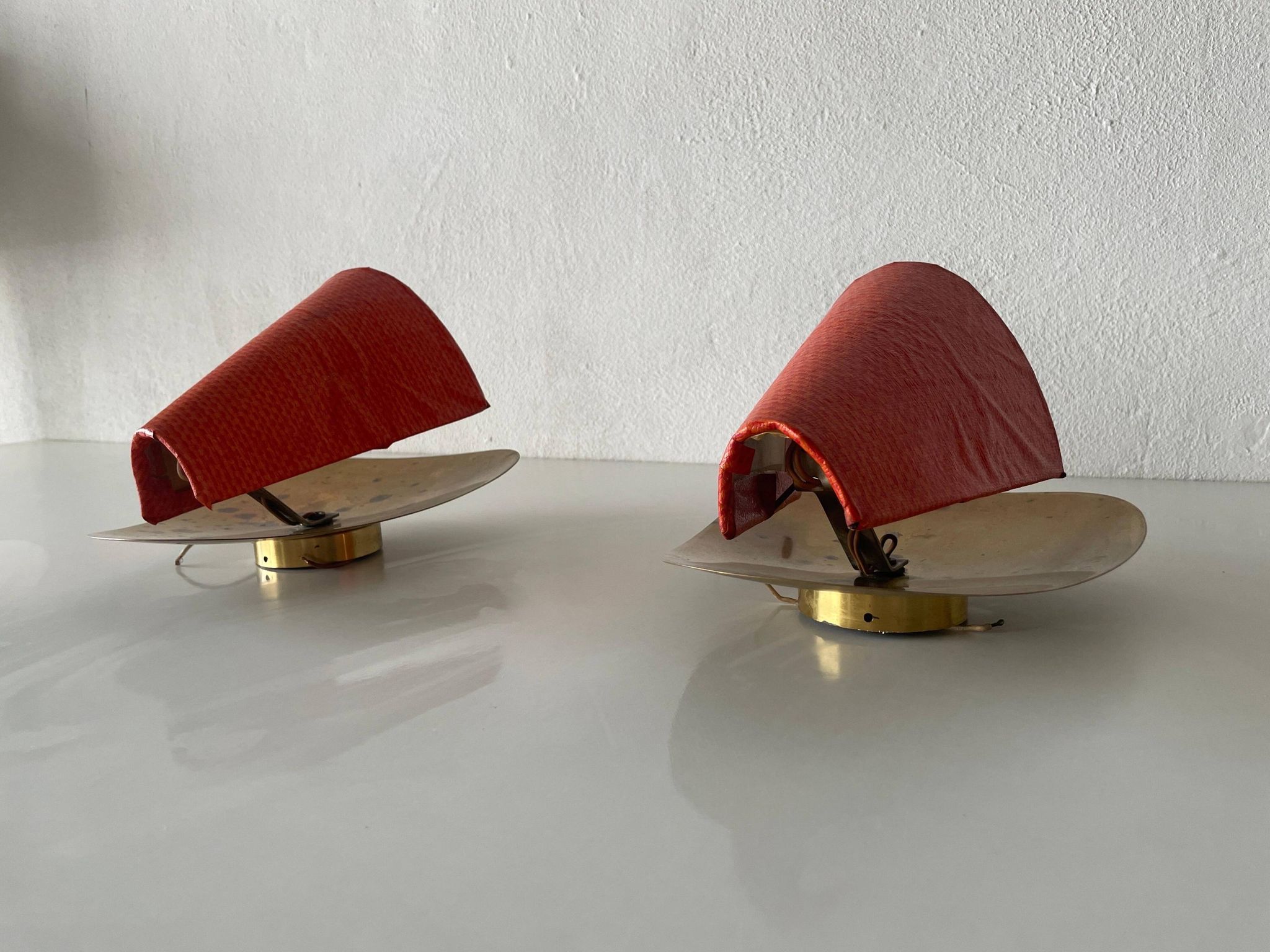Pair of orange plexiglass and curved brass wall lights, 1950s, Germany
