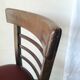 Set of 19 vintage wooden bistro chairs with red faux leather.