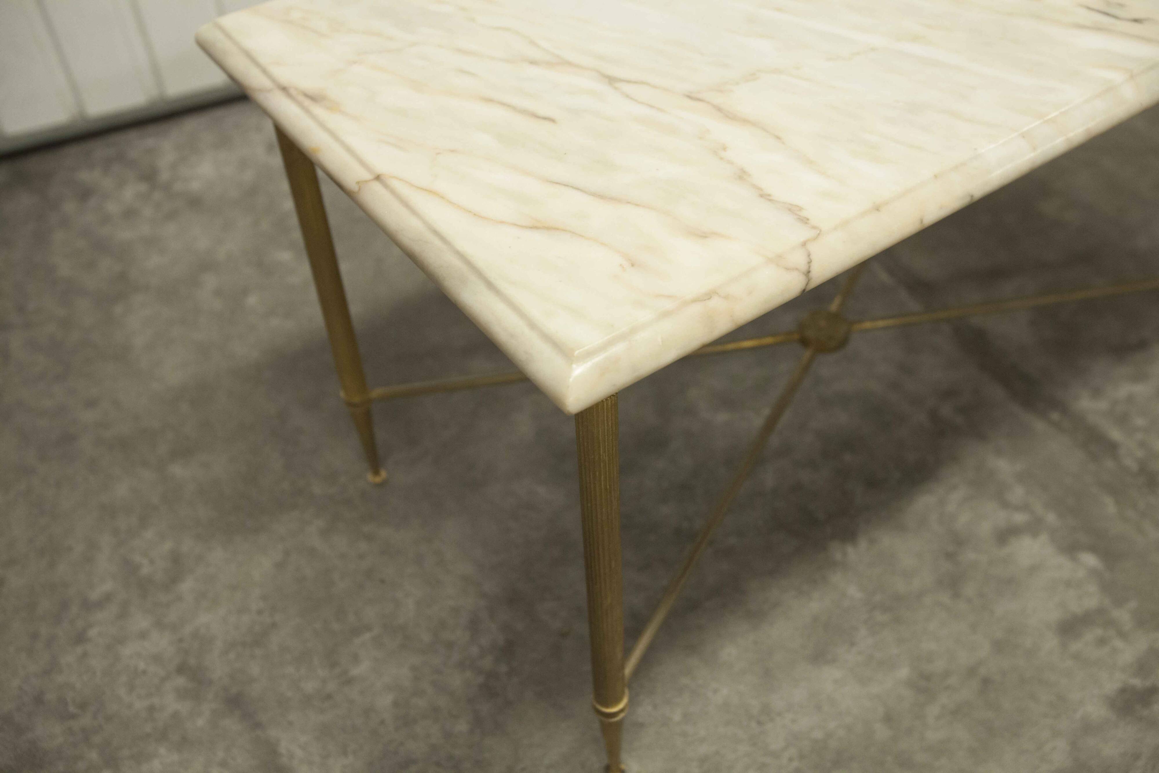 Marble coffee table with brass legs, height 46 cm.
