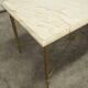 Marble coffee table with brass legs, height 46 cm.