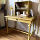 Desk table from the late 19th century, painted mustard, with turned stretcher.