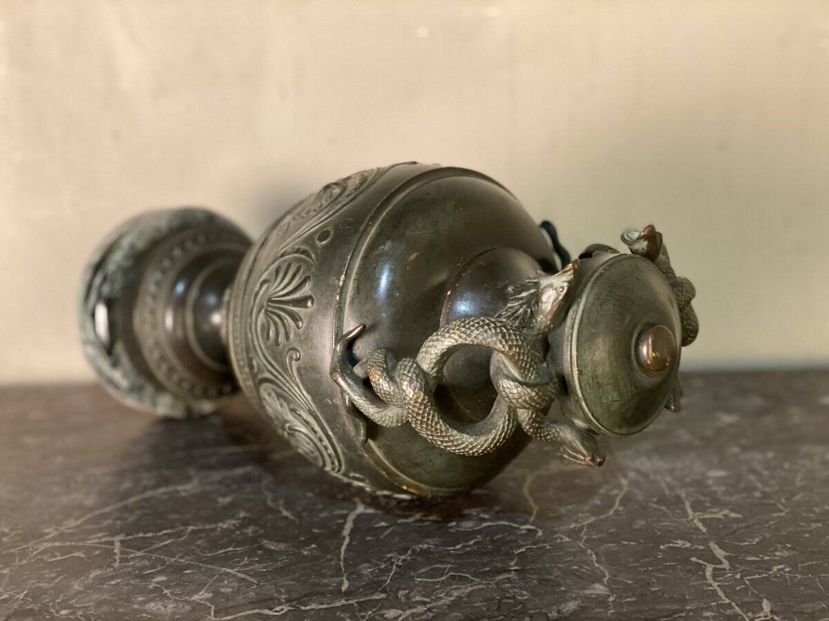 Bronze vase with snakes and a green patina, in the antique style.