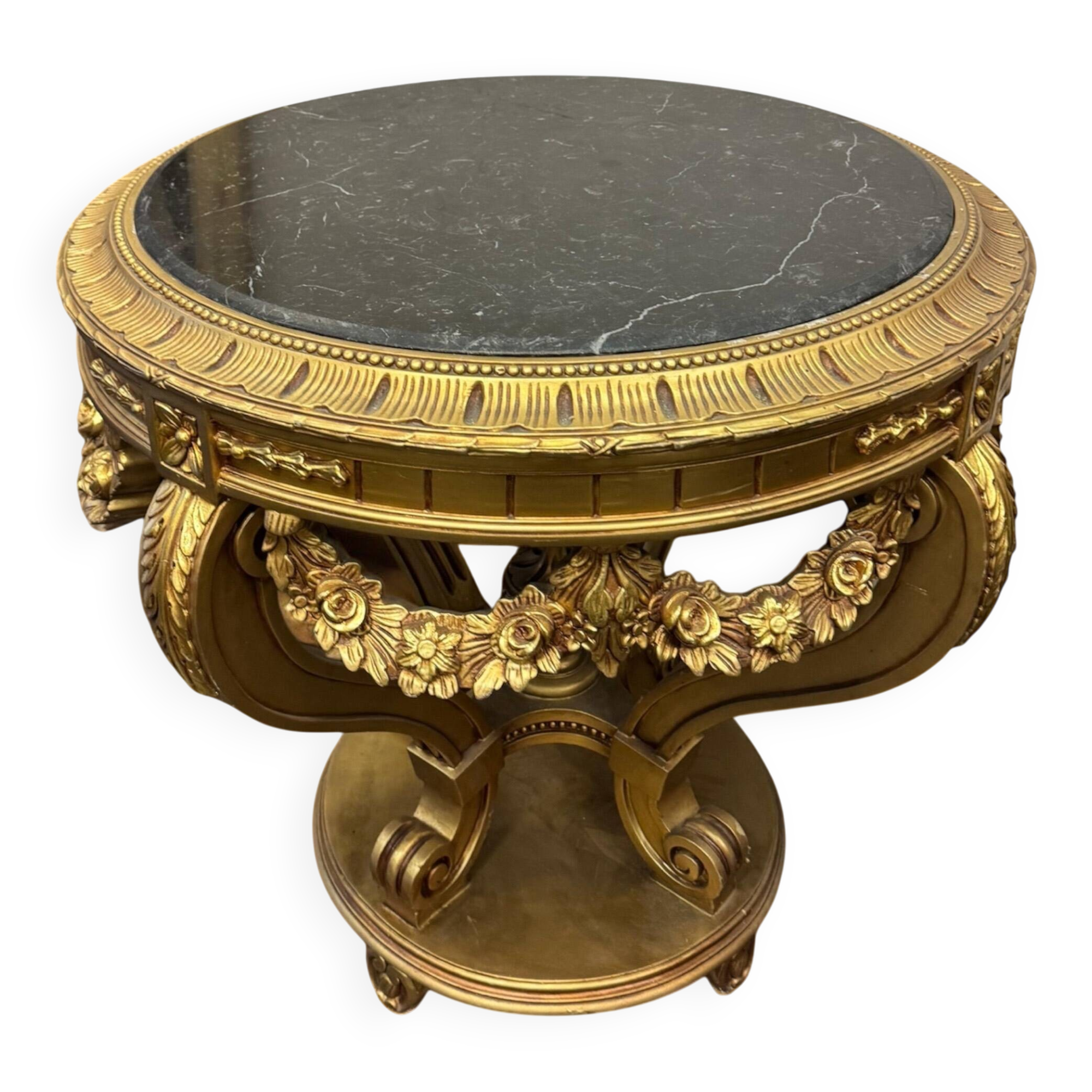 A round Louis XV style table in carved gilt beechwood with a black marble top