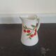 Small ancient porcelain pitcher decorated with cherries