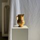 Large antique handmade ochre yellow jug with a pink flower pattern.