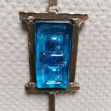 Wall-mounted candle holder in cast iron and hard pressed blue glass.