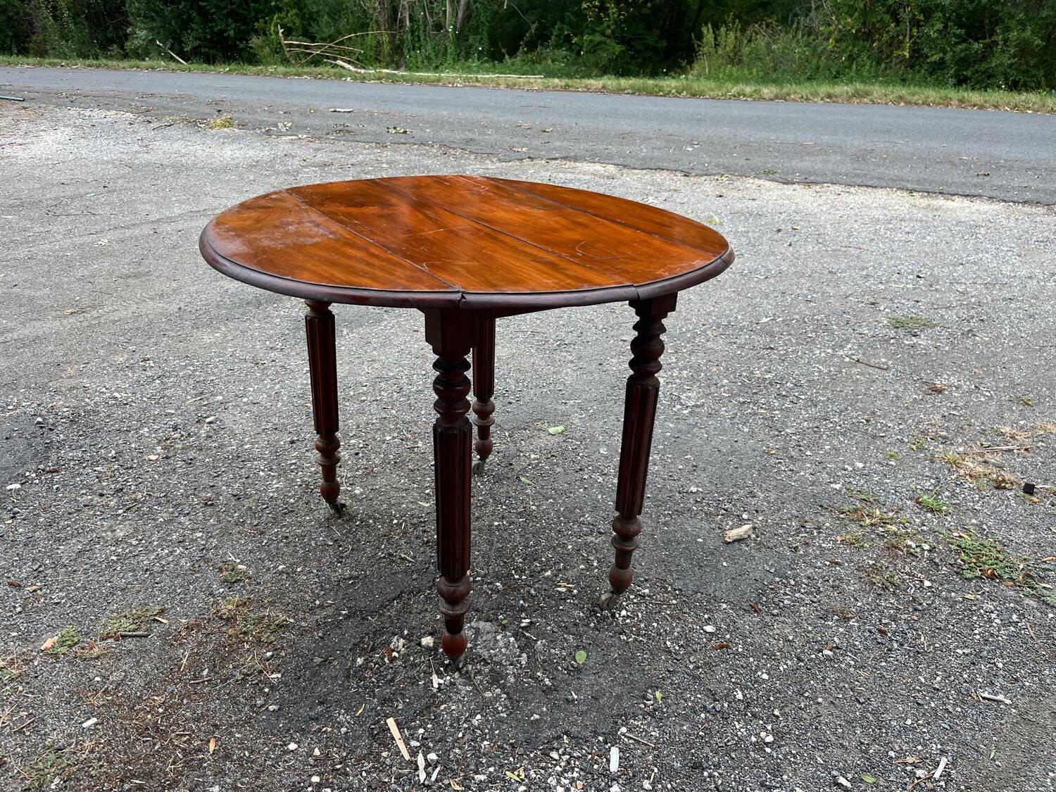 Antique round mahogany table, turned and fluted legs