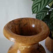 Artisanal turned olive wood vase with varnish.