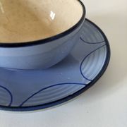A pair of glazed ceramic cups and saucers from the 60s-70s.