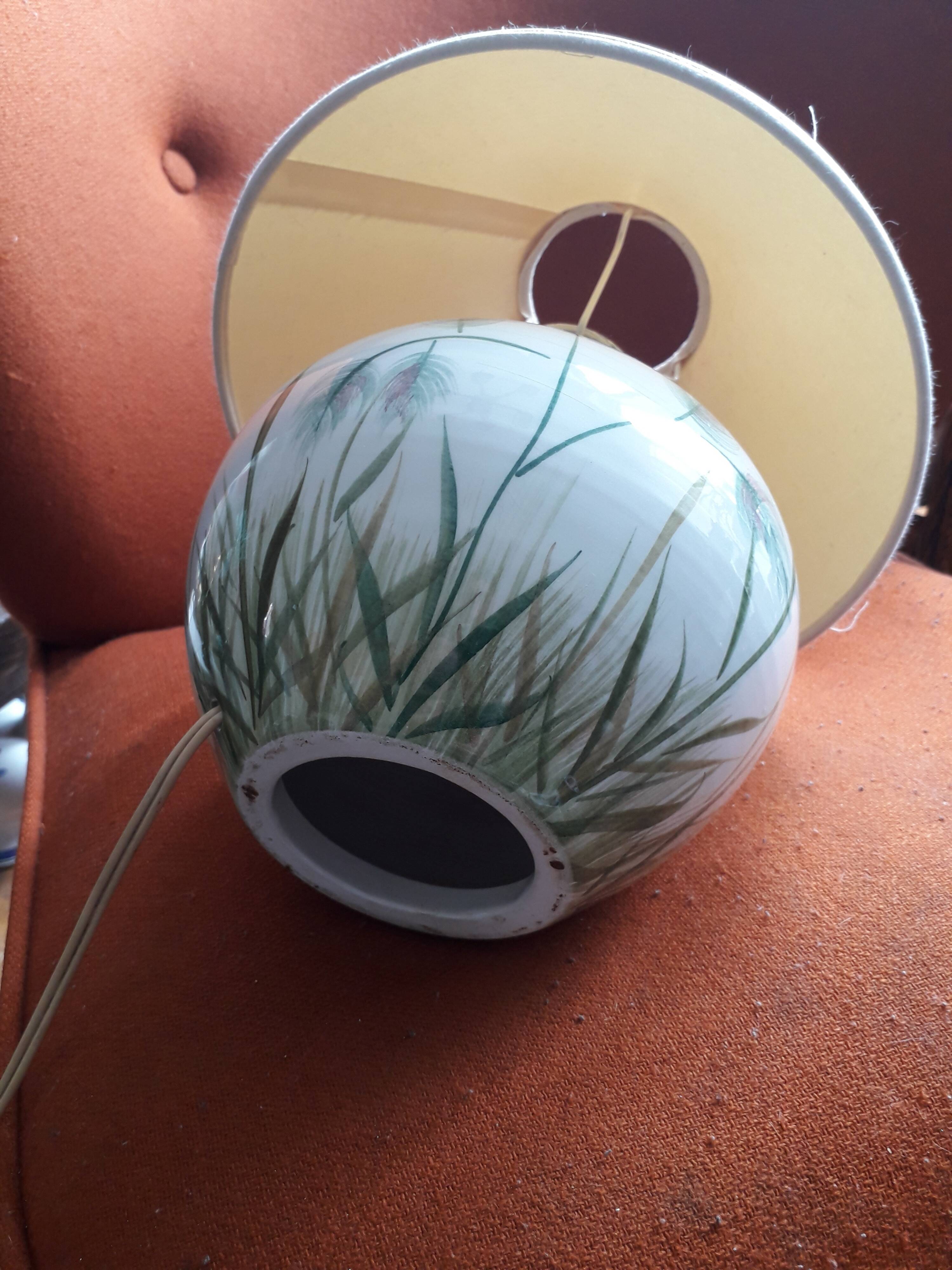 Antique ceramic lamp with a floral design.