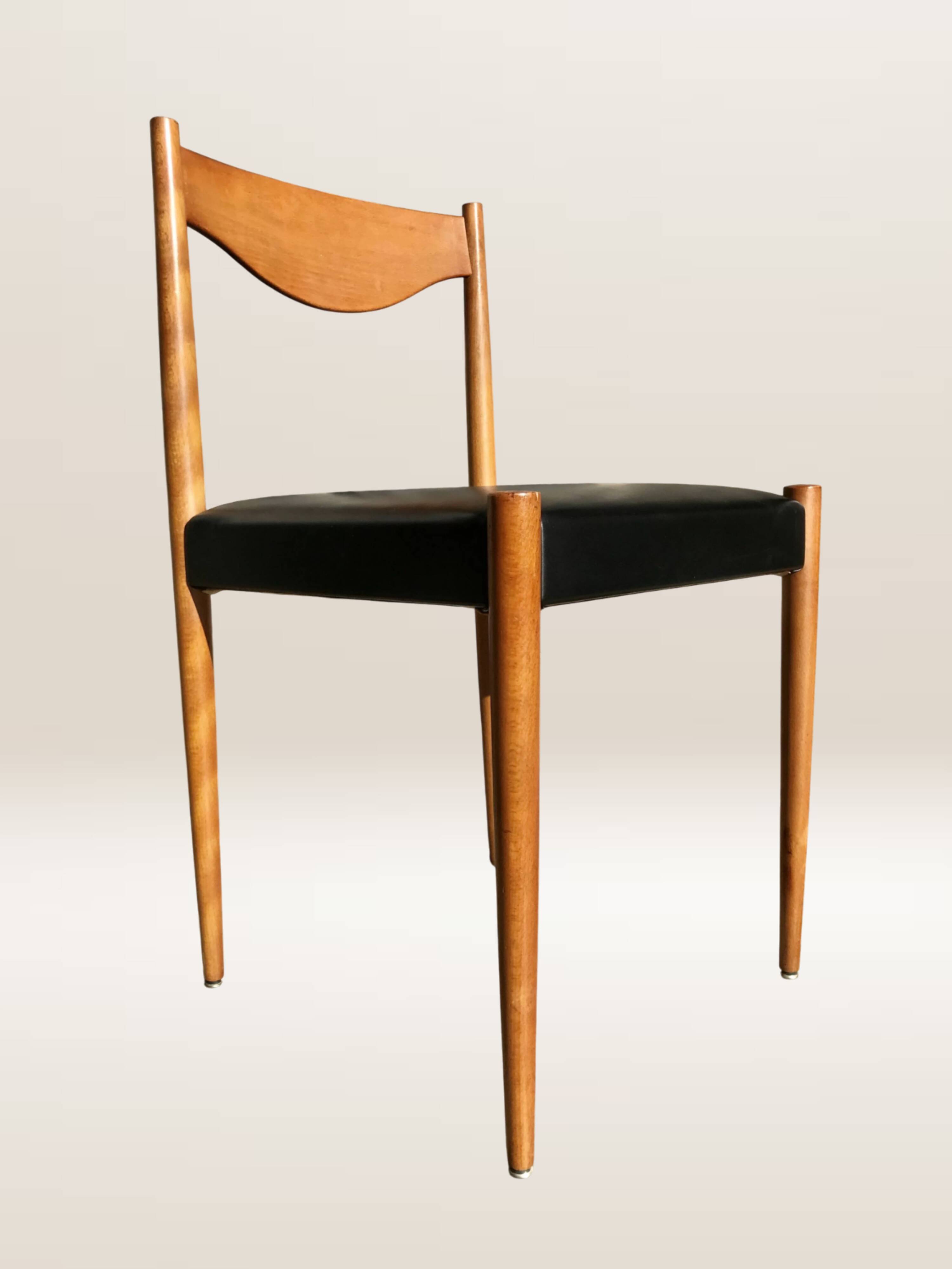 Set of 6 modernist chairs with black faux leather seats.