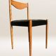 Set of 6 modernist chairs with black faux leather seats.
