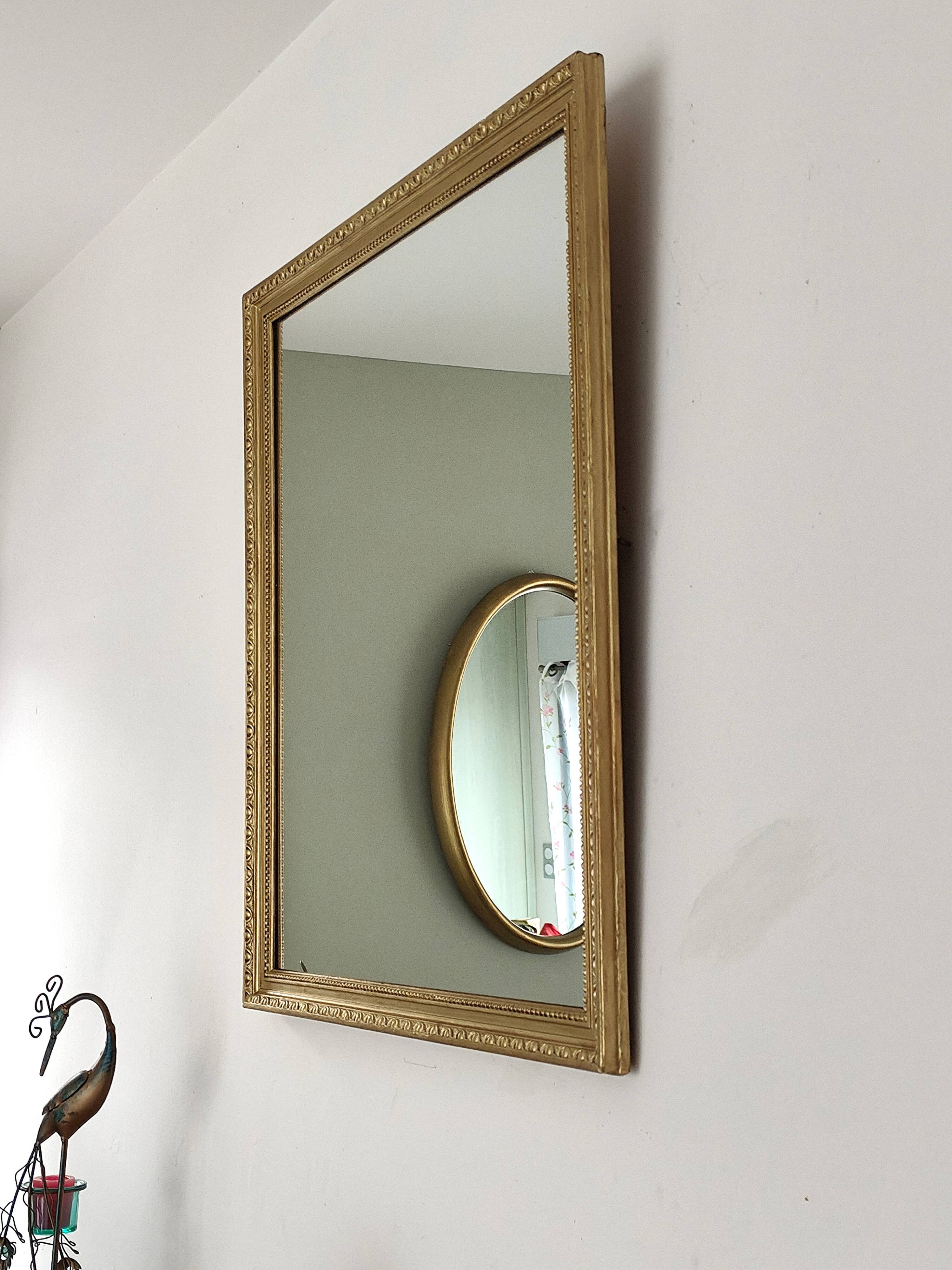 Antique mirror with a gilded frame and beaded border.