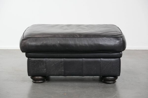 Grand et intemporel pouf noir en cuir de vache dans le style anglais.