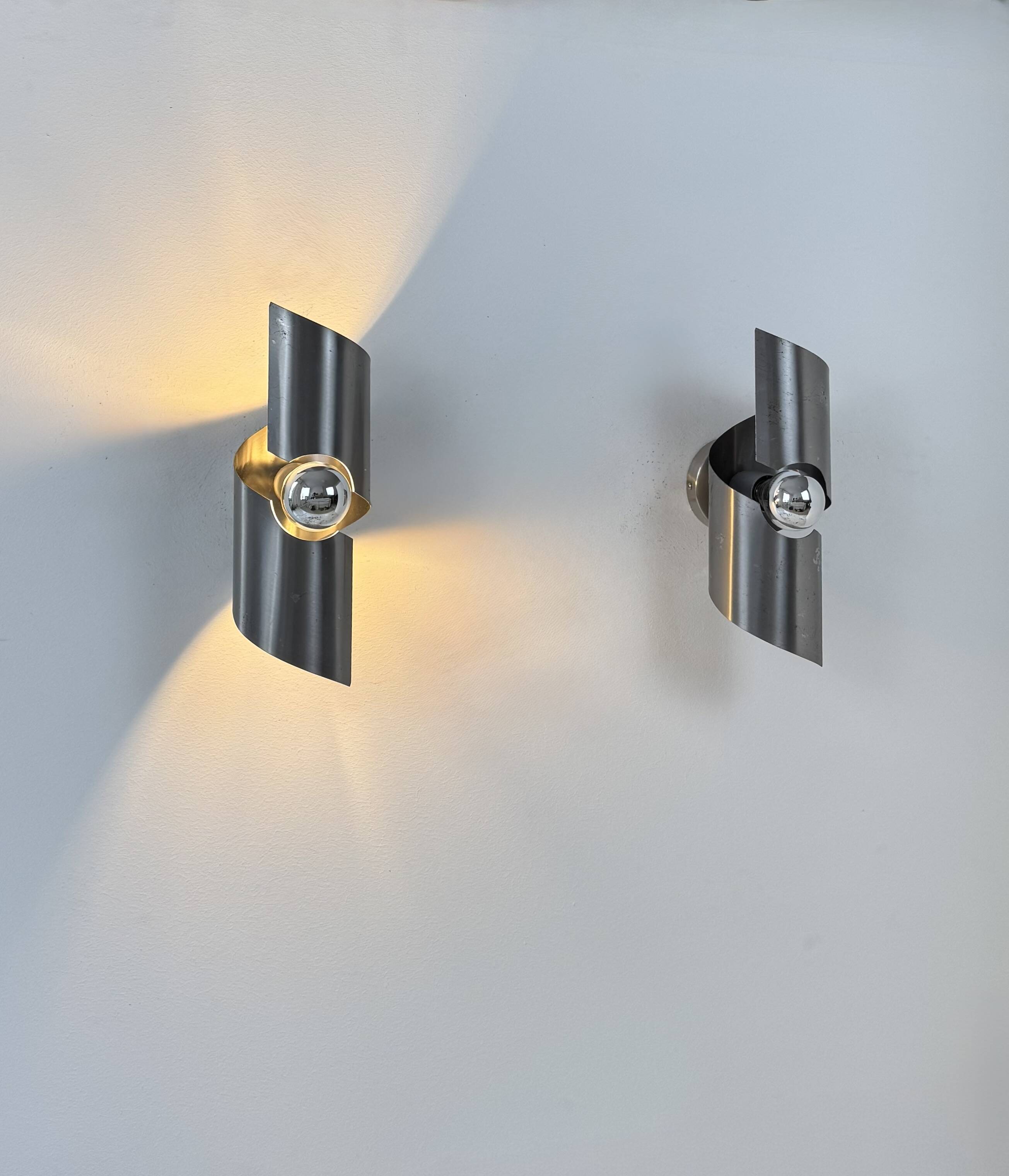 Pair of vintage wall lights, curved patinated steel, France, 1970.