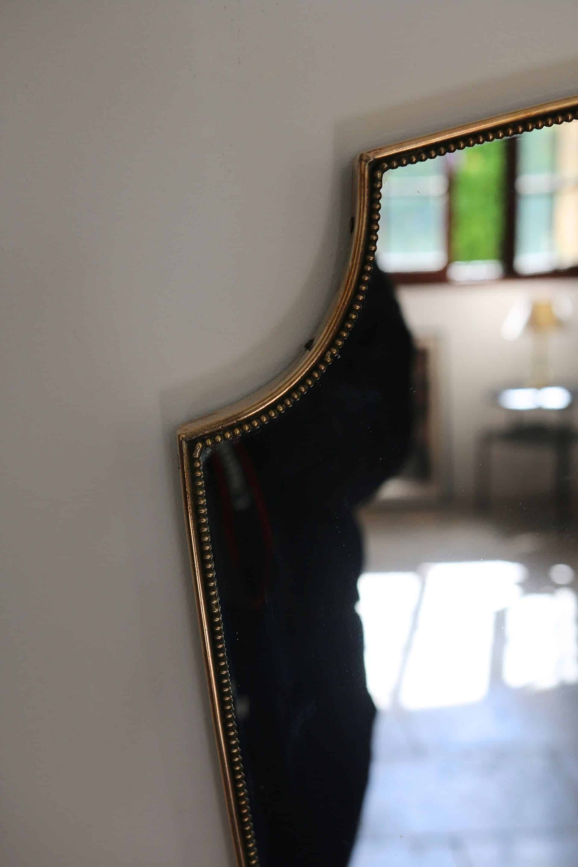 Brass mirror with crest, bead frieze, Italian design style.