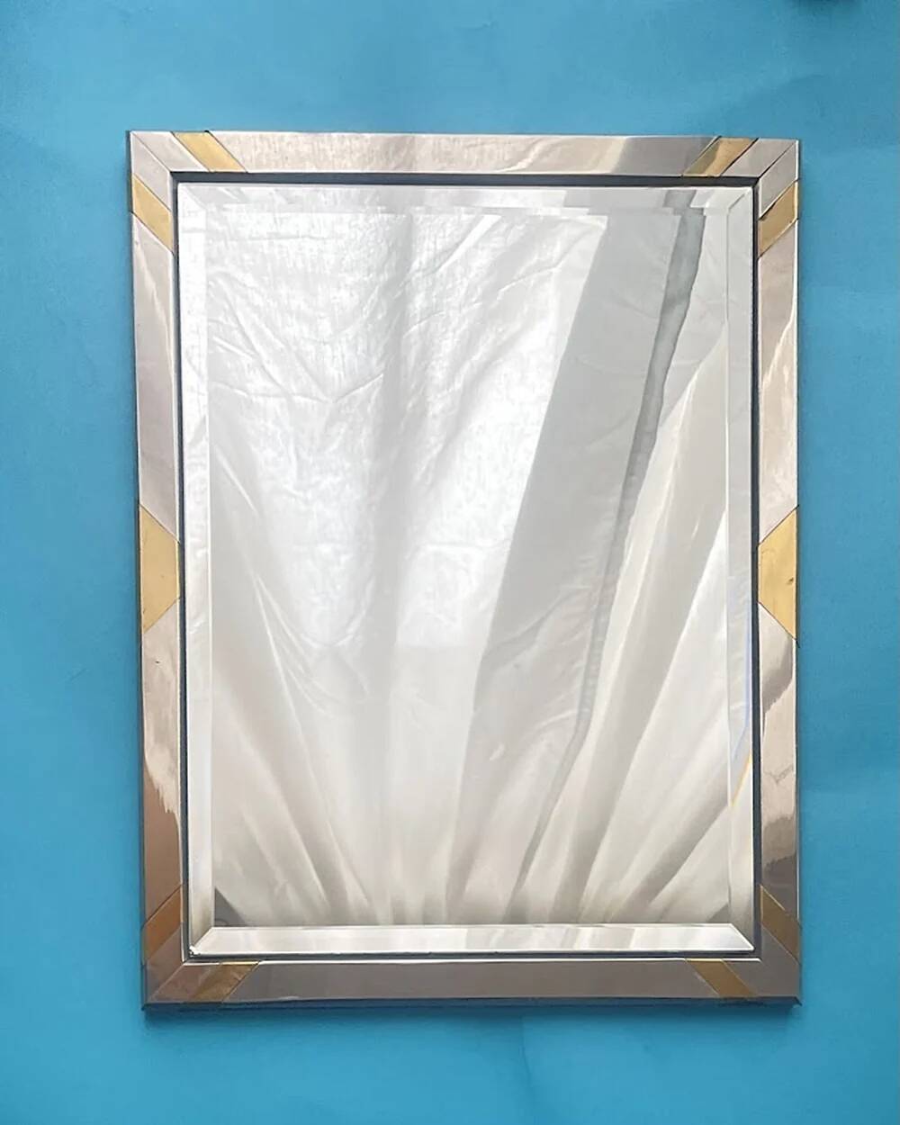 Faceted modernist wall mirror in steel and brass, geometric mixed metal frame 1970s.