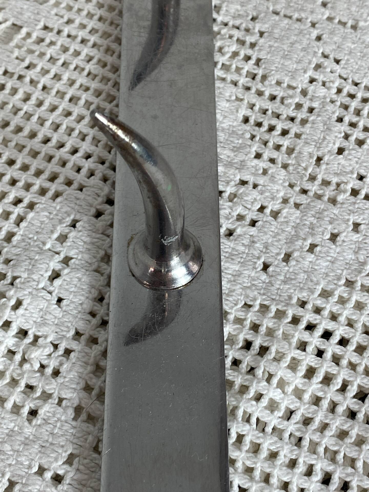 Stainless steel butcher's hook, known as a "wolf tooth bar."