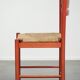 Red vintage wooden chair from the 1970s with a woven wicker seat