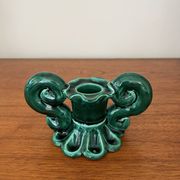Green ceramic candlestick with curled handles.