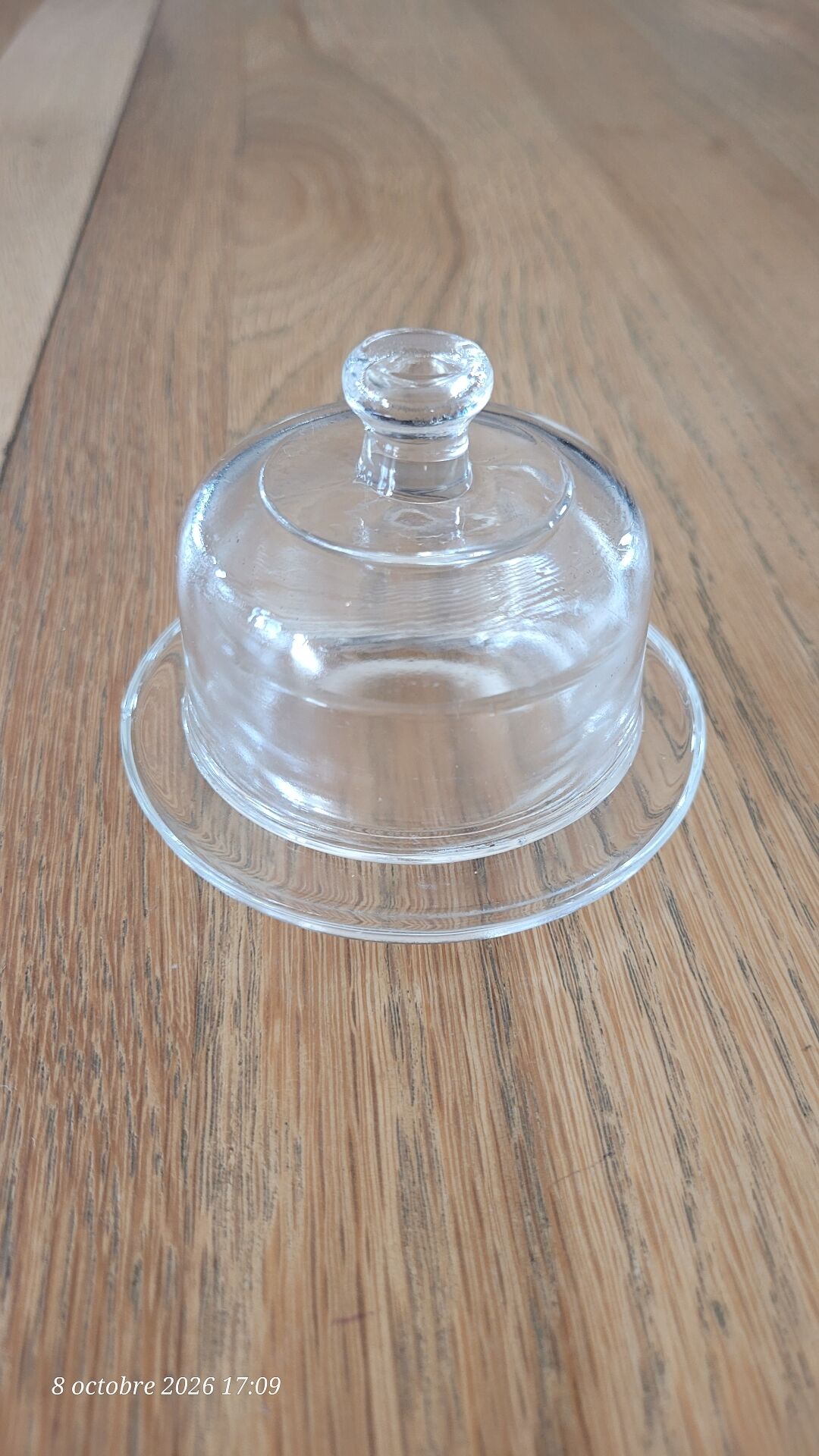 2 transparent glass butter dishes accompanied by their matching cloches.