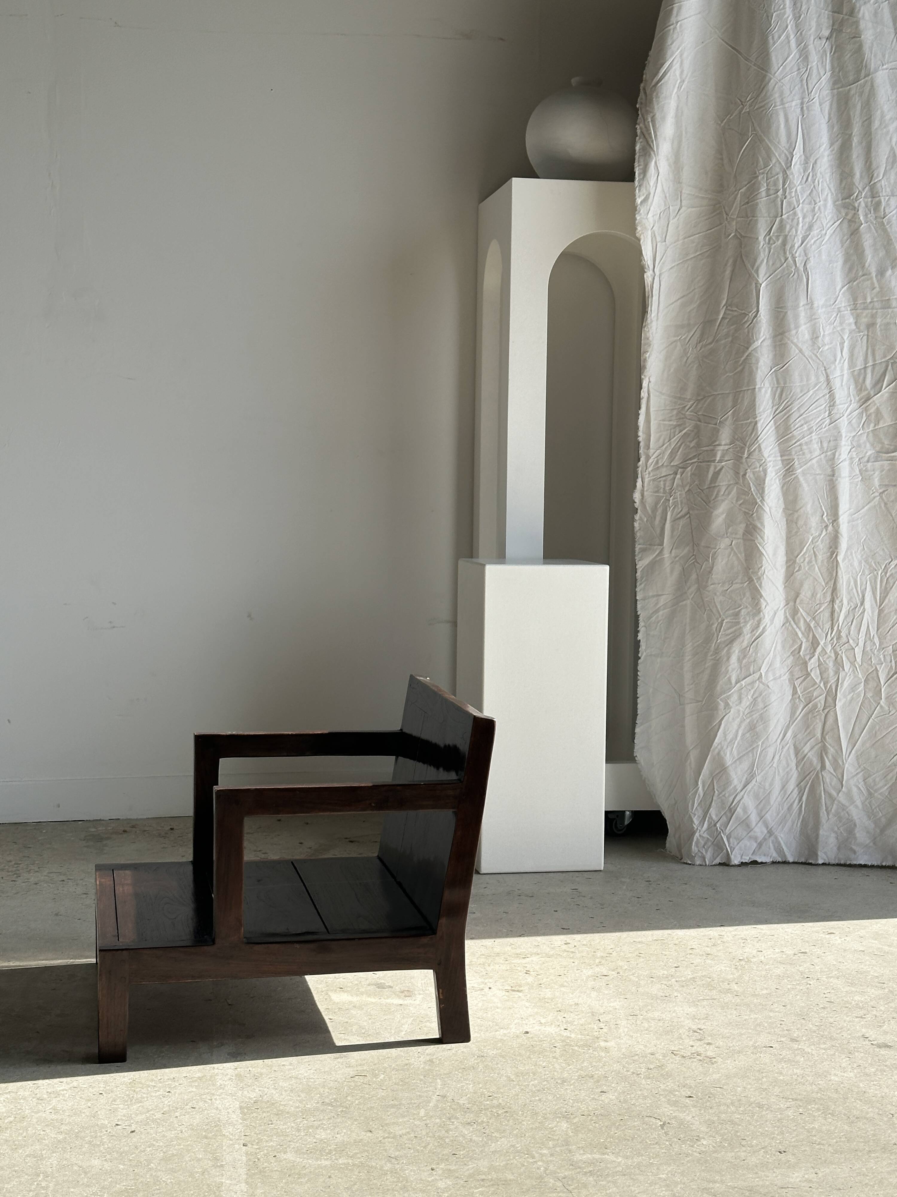 Small low armchair in varnished brown wood