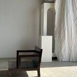 Small low armchair in varnished brown wood