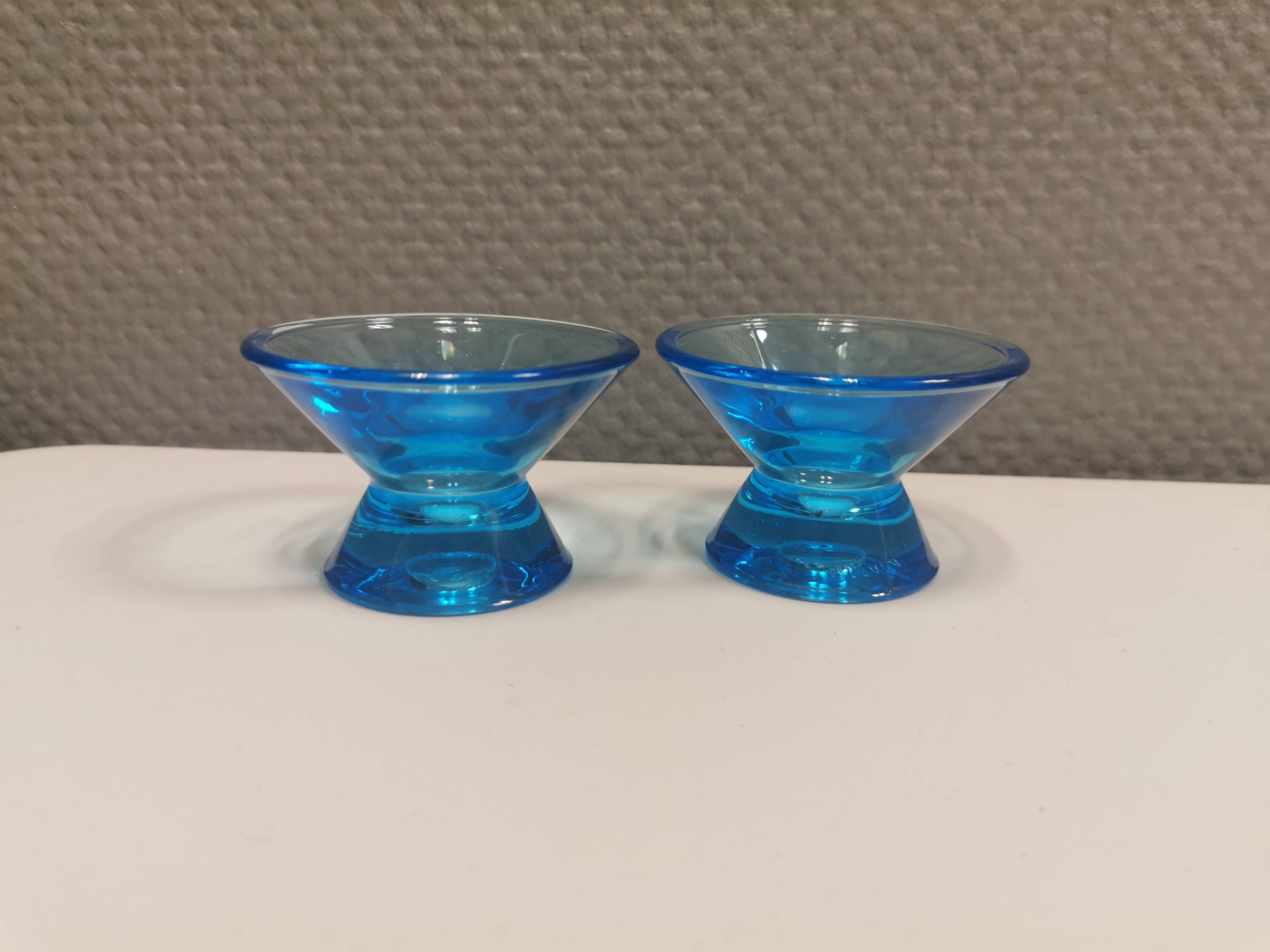 Two small candle holders in blue glass from the well-known Finnish company Ittala.