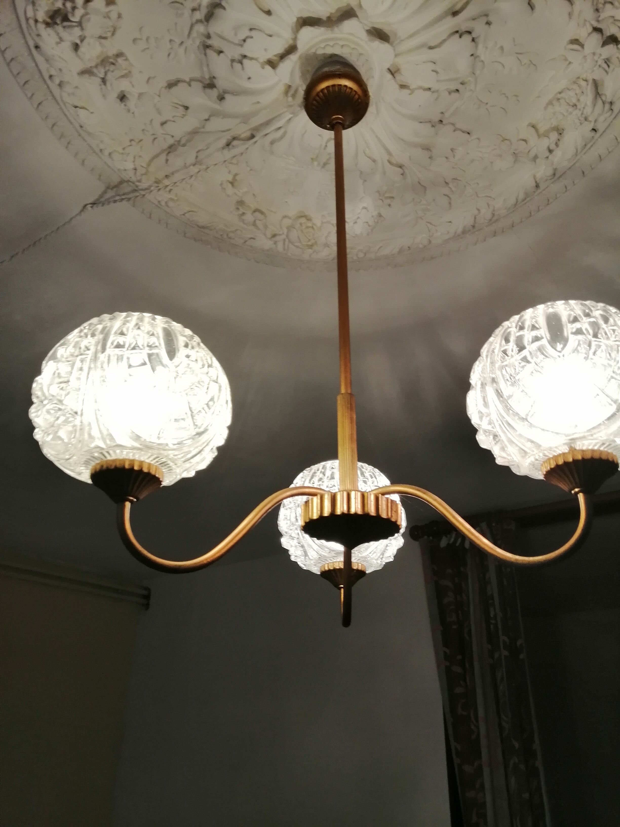 antique chandelier has 3 globes