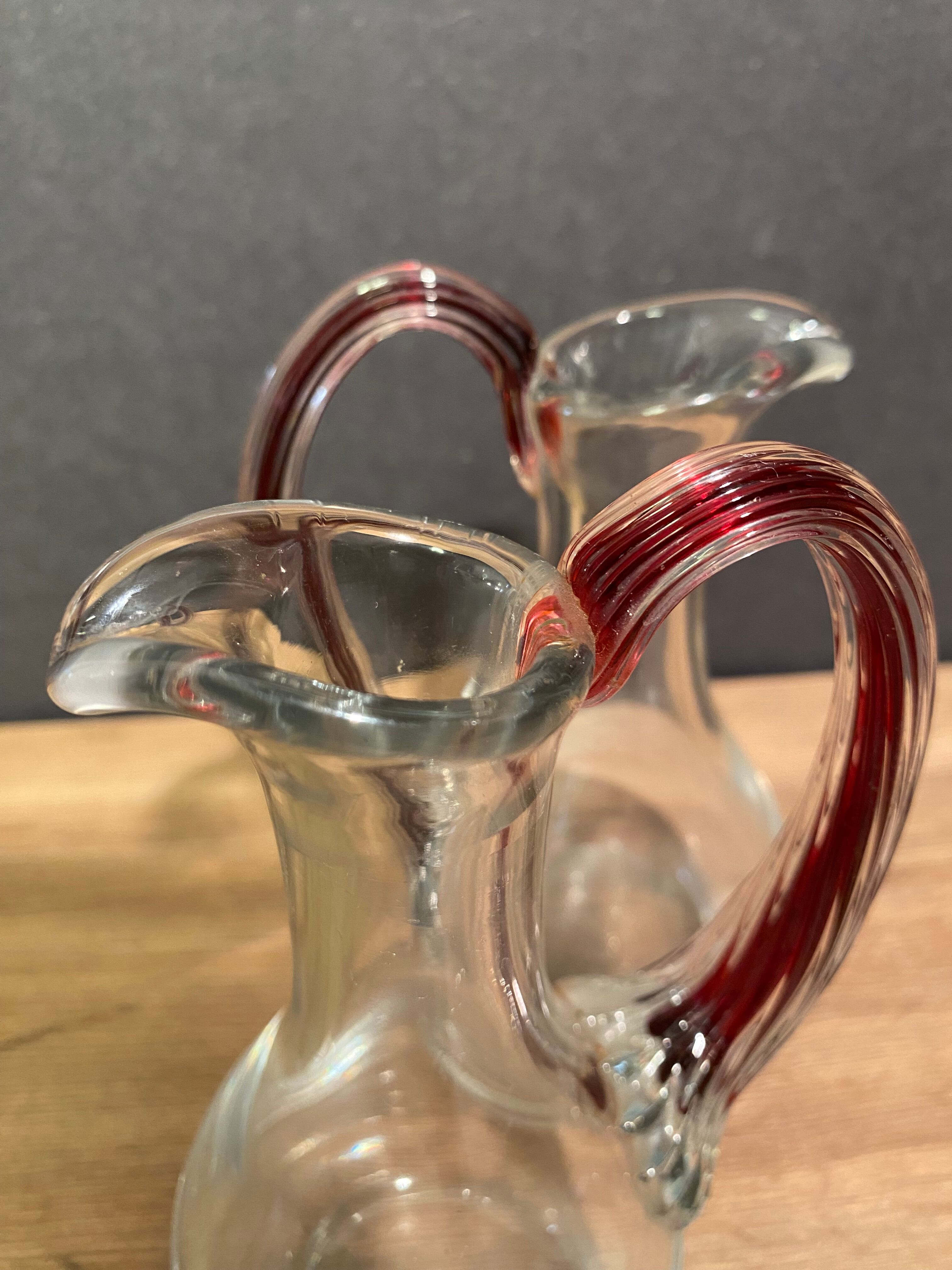 pair of crystal buires, handles with red tinted net decoration in the mass