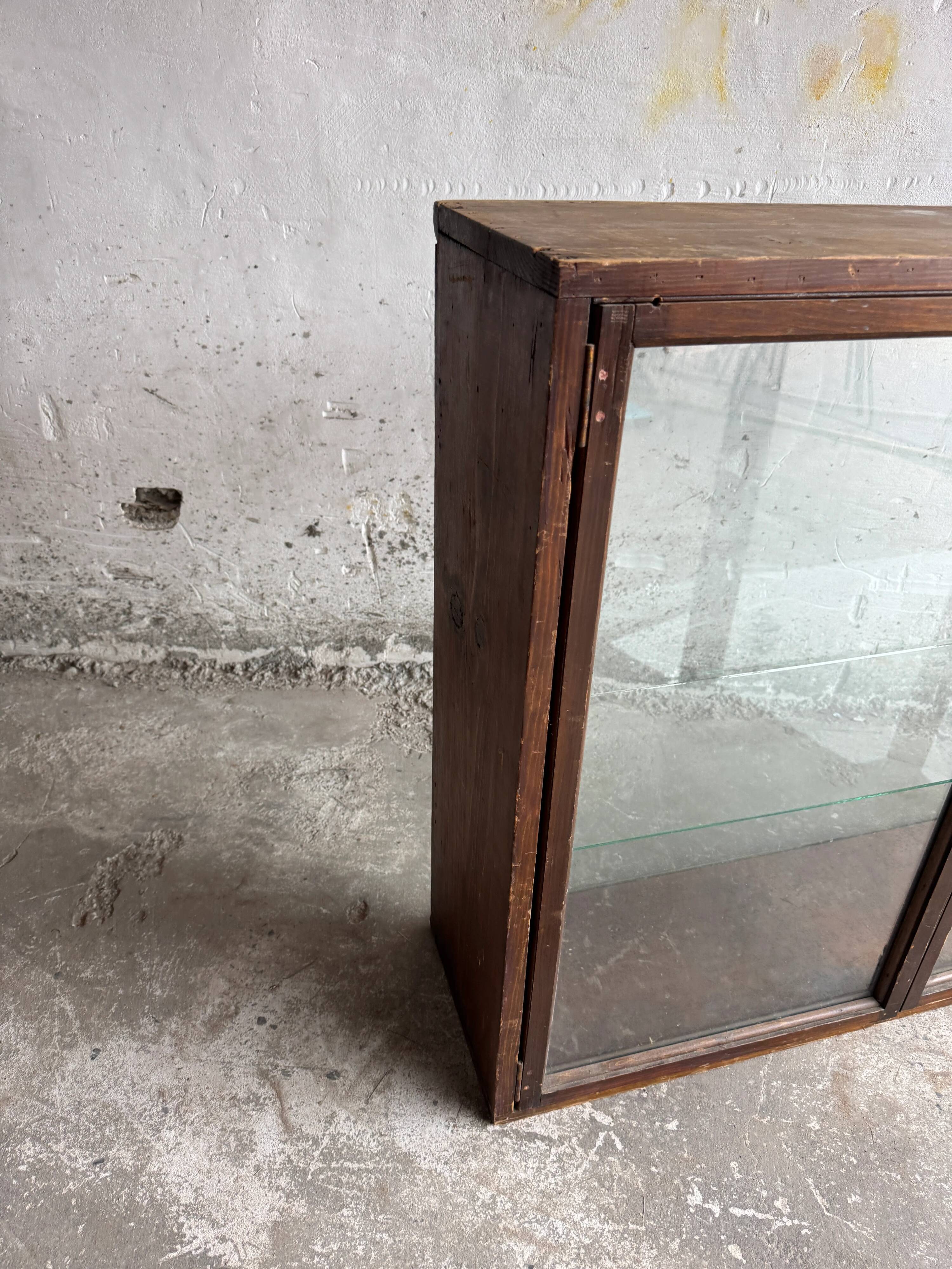Dark-stained wood and glass vintage display cabinet — early 20th-century wall-mounted showcase