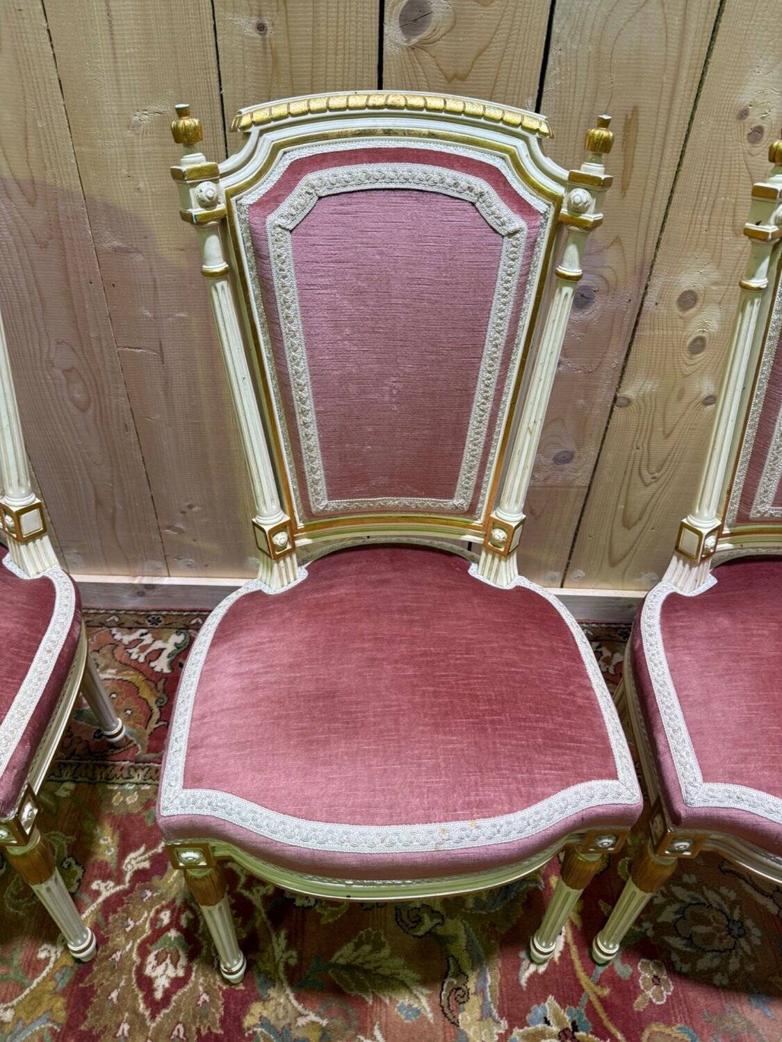Louis XVI dining room table set with painted wood, gold accents, and pink velvet.