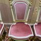 Louis XVI dining room table set with painted wood, gold accents, and pink velvet.