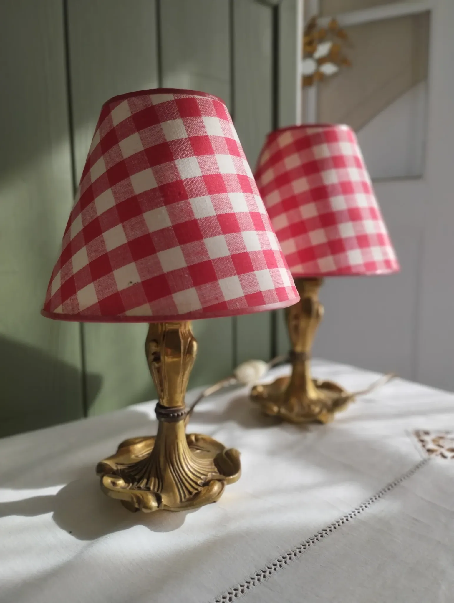 Pair of small lamps in gilded bronze by Petitot and red gingham lampshades.