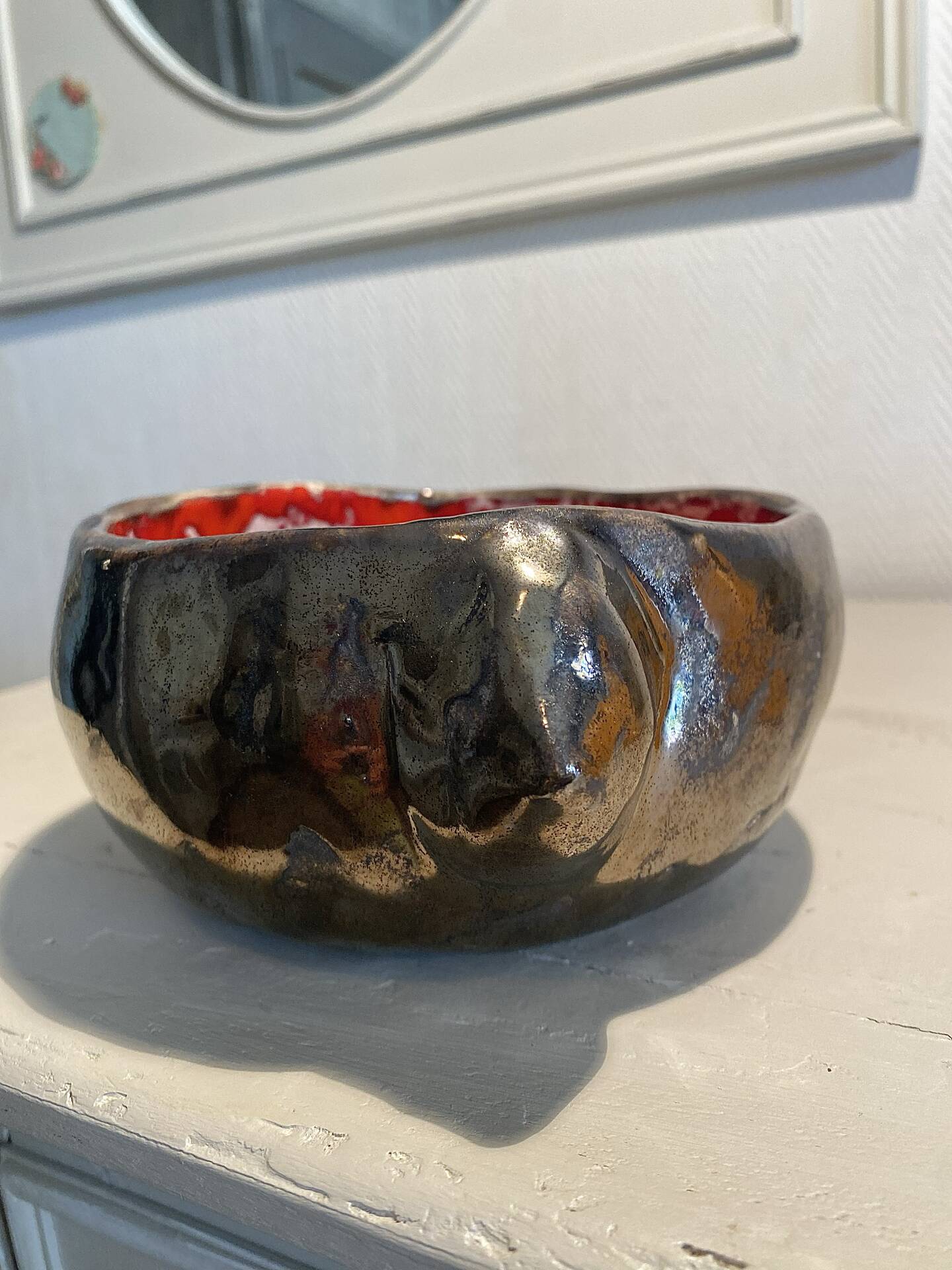 Deep red glazed and metallic ceramic catchall.