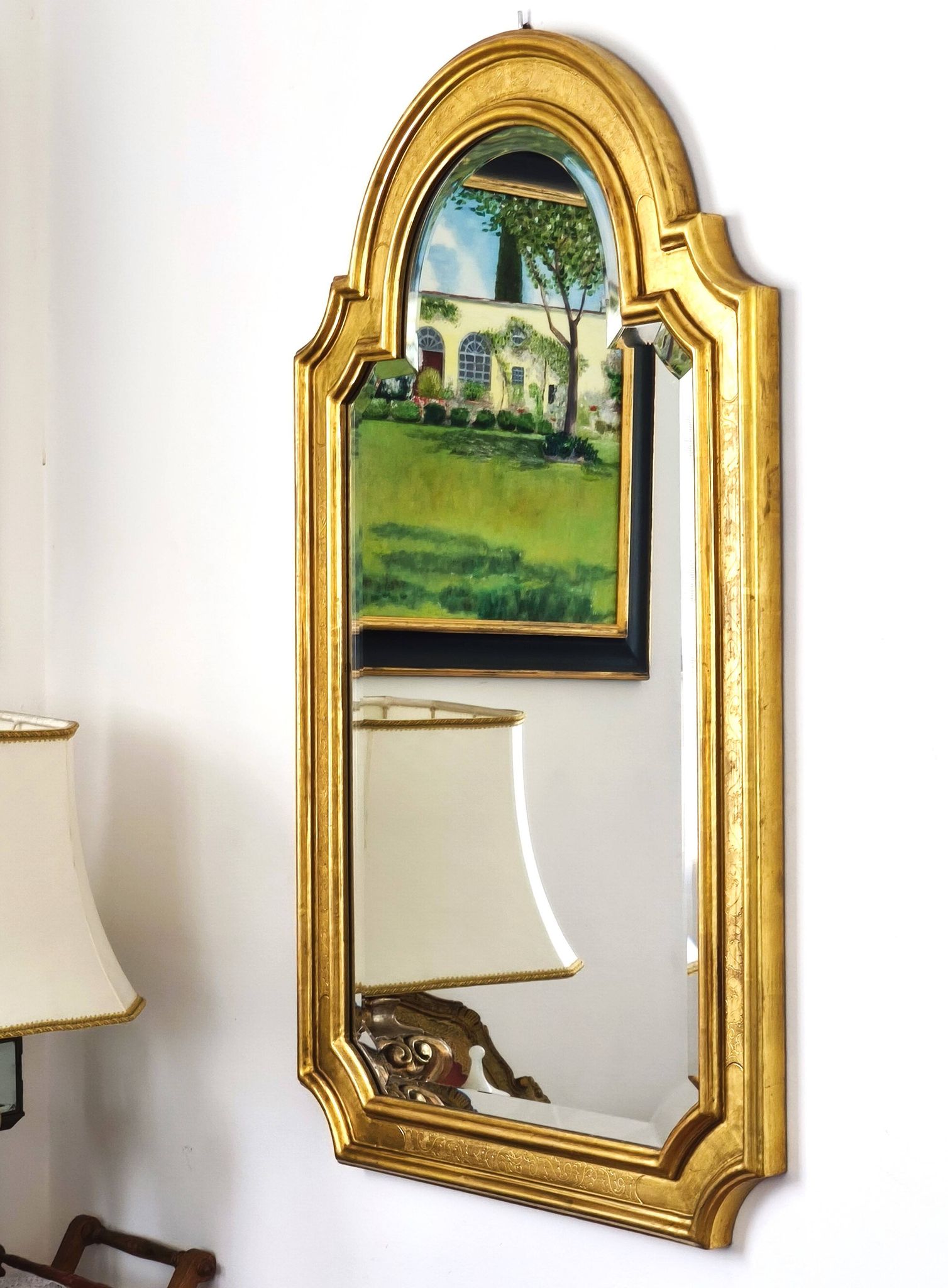 Florentine arched mirror in gilded wood with gold leaf.