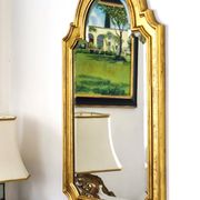Florentine arched mirror in gilded wood with gold leaf.