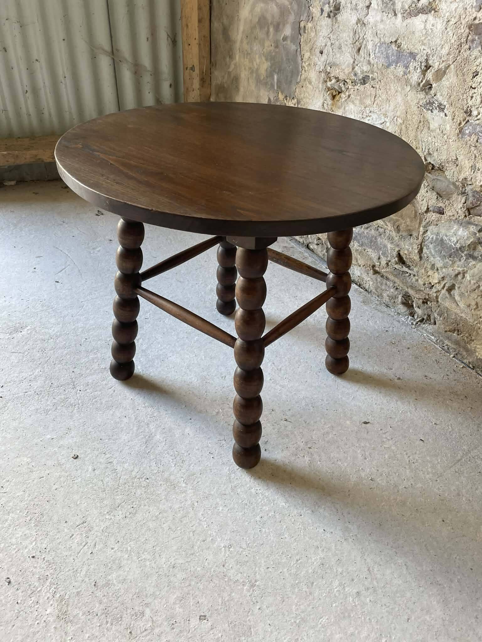Round wooden coffee table with turned legs.