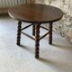 Round wooden coffee table with turned legs.